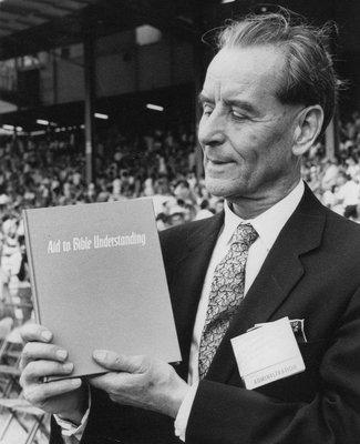 Jehovah's Witness Fred Franz shows off the new Watchtower Bible and Tract Society publication.