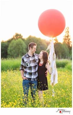 Engagement photo featuring a coral balloon with white & gold tassels.