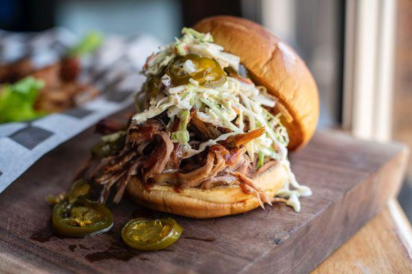 Pulled Pork Sandwich topped with coleslaw and candy jalapeños.