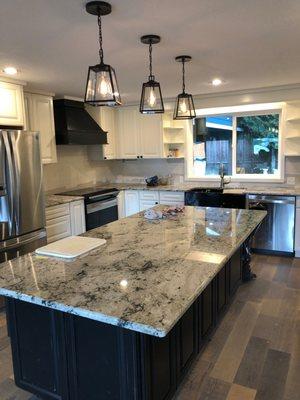 Kitchen renovation- after. New window, cabinets, counters, flooring, lighting, sink & faucet. In-house permit & design services.