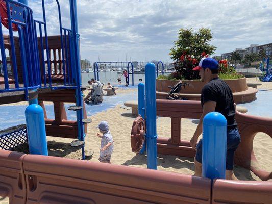 One of the play structures with bucket swings in the background.