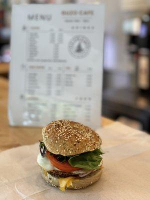 breakfast sandwich served with turkey sausage egg lettuce, tomato onions on a everything bagel