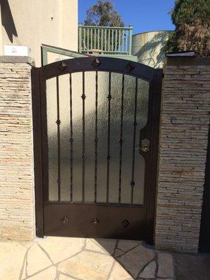 Custom iron gate with bronze finish and frost glass.