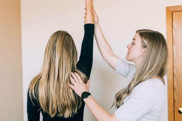 Physical therapist performing shoulder evaluation.