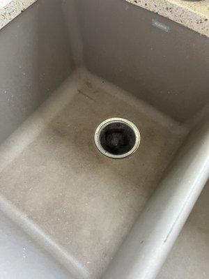 Inside of the sink with food still stuck to the side