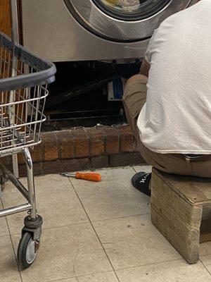 The owner fixing the machine while the store is open