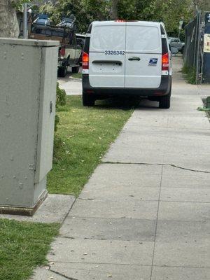 Mailman using the sidewalk and grass to leave after parking illegally in handicap