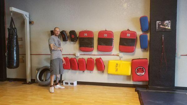 CEO and founder of Roundhouse Fitness displaying all the pads we use to strengthen and develop all your skills