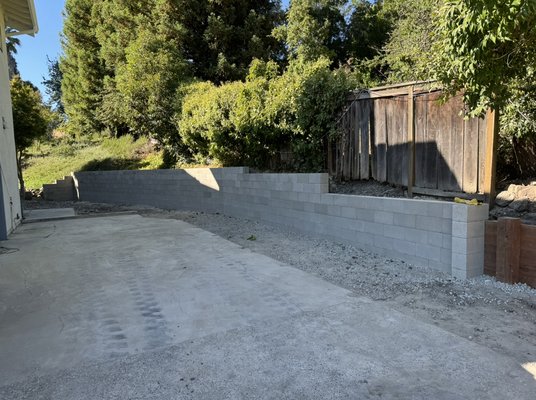 Cinder block retaining wall with a small Redwood retaining wall