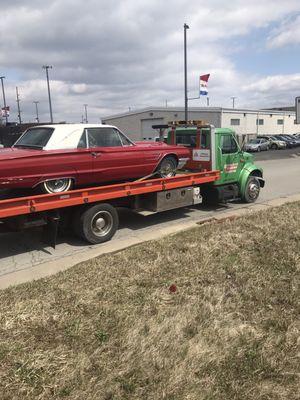 International rollback carrier hauling an old Thunderbird.