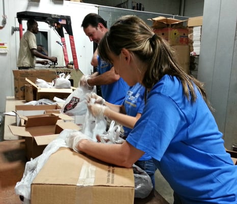 A team of volunteers packing bags of food for food pantry