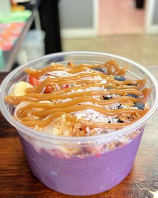 Açaí bowl topped with fresh fruits and your choice of drizzle.