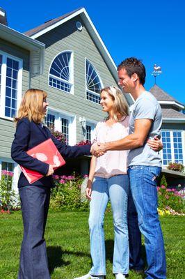 Realtor and Couple Looking at a House.