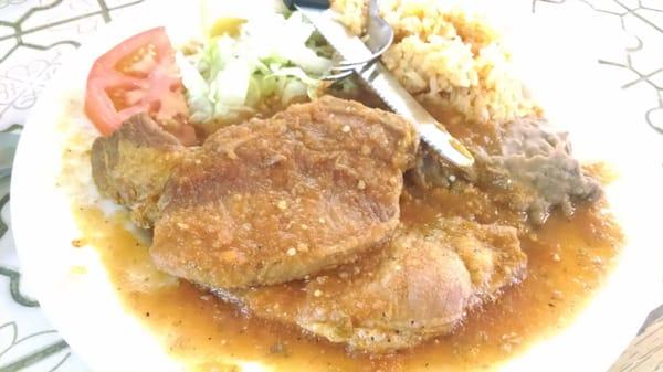 Pork chops in red hot sauce with rice and beans. Just awesome!