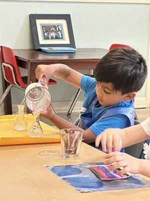 Practical Life activity-Grace & Courtesy - Child pouring water 1:2, working on his hand-eye coordination, focus, concentration