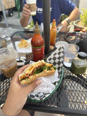 Green juice, iced coffee, and breakfast sandwich with bacon