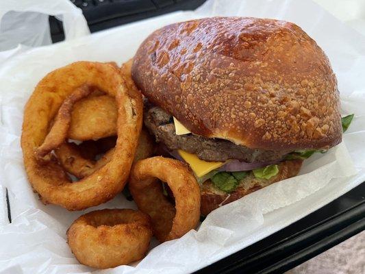 Take out burger with bacon and onion rings.