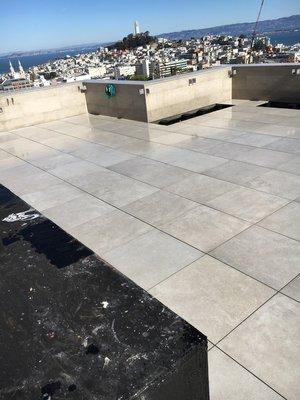 2x2 Porcelain Pavers Installed On Top Of Adjustable Pedestals. Pedestals Sit Atop Waterproof Membrane on Roof.