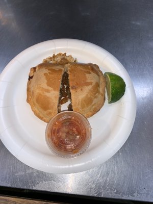 Beef Empanada with a slice of lime and hot sauce