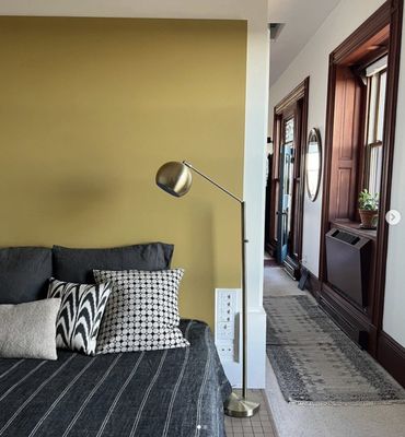 Natural woodwork through out this condo, pairs beautifully with the accent wall behind the bed.