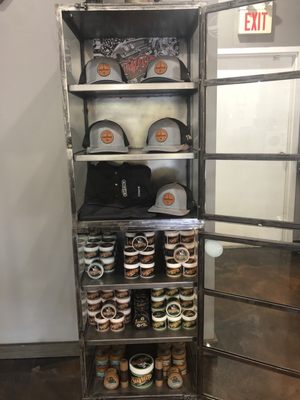 Display case with custom hats and Suavecito pomade