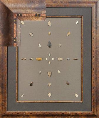 Native American arrowhead collection in a burl, inlaid frame.