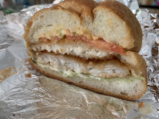 Half eaten fried flounder sandwich. Delivered with the fish perfectly crispy. Yum!