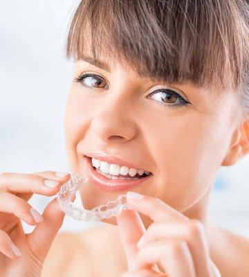 Made from a clear plastic material, Invisalign aligners look like thin sports mouthguards.