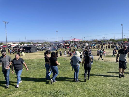 Vendors are spread out over a large field, with no shade.