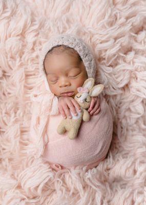 Newborn baby girl with a stuffy.