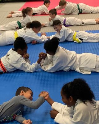 Kids enjoying a fun arm-wrestling activity at Kickboxing Plus Martial Arts Academy in Matawan, NJ. Join us at Park Plaza, 343 NJ-34.