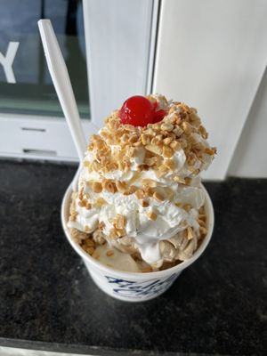 Small (minor) maple walnut with marshmallow topping and whipped cream small nuts and a cherry on top.