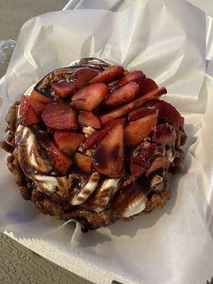 Chocolate funnel cake with strawberries, whipped cream, and chocolate sauce