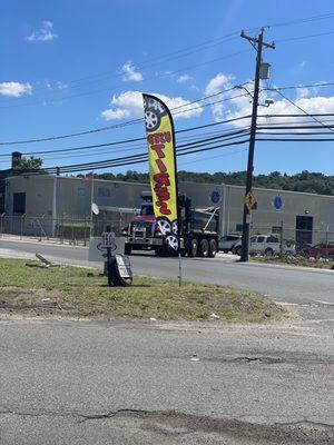 Yellow used tire flag in front of parking lot