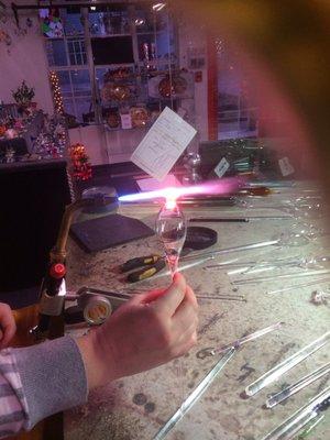 My wife taking a glassblowing class, making an ornament.