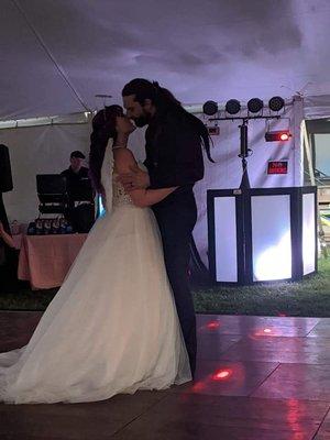 Bride and groom's first dance with the DJ booth in the background.