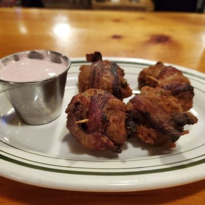 Stuffing wrapped in bacon with a cranberry cream cheese sauce