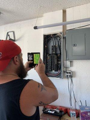 Using a FLIR camera to check for hot spots inside an electrical panel.