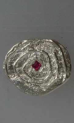 sterling silver swirlie design button. burnish set with a square, genuine ruby.