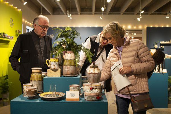 Customers looking at pots in the gallery.