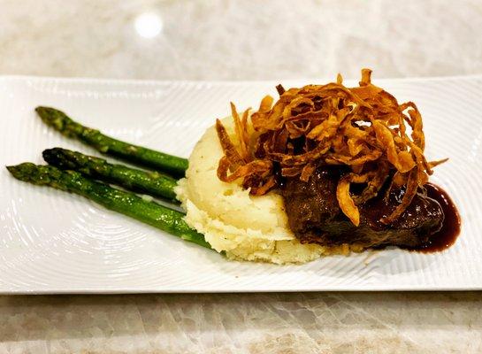 Braised Beef on garlic mashed potatoes grilled asparagus and garnished with fired onions