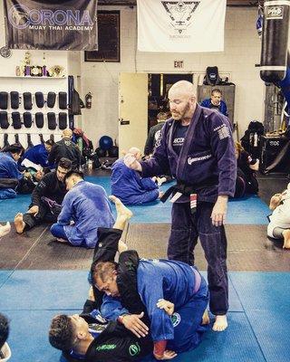 Professor Brent Burniston giving details on how to finish a triangle choke to one of the students.