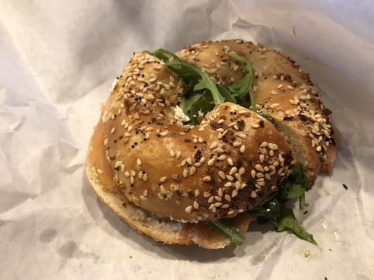 Lox bagel with cream cheese, capers, tomato, and arugula