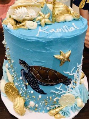 Three tier vanilla cake with strawberry whipped cream filling. Butter cream frosting. Sea turtle ocean theme cake.