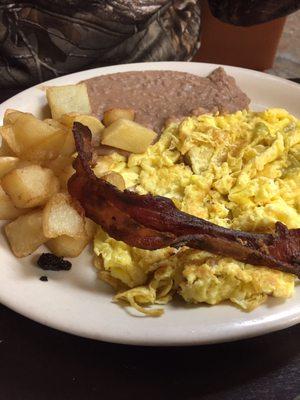 Huevos rancheros with scrambled eggs (and sauce on the side). Comes with one crispy piece of bacon, and some solid papas.