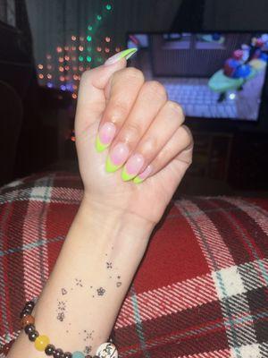 Beautiful green french tip nails with tiny pink hearts on each nail