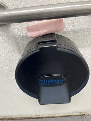 A used maxi pad on the toilet paper holder