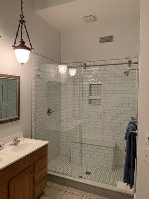 Beautiful tiled walk in shower with dual shower heads and bench in Master Suite.