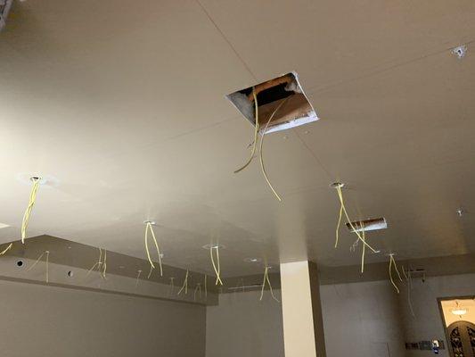 Retrofit recessed lights on remodel house preparing wires.