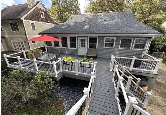 This is a deck using gray Trex decking and handrails with round black aluminum balusters.